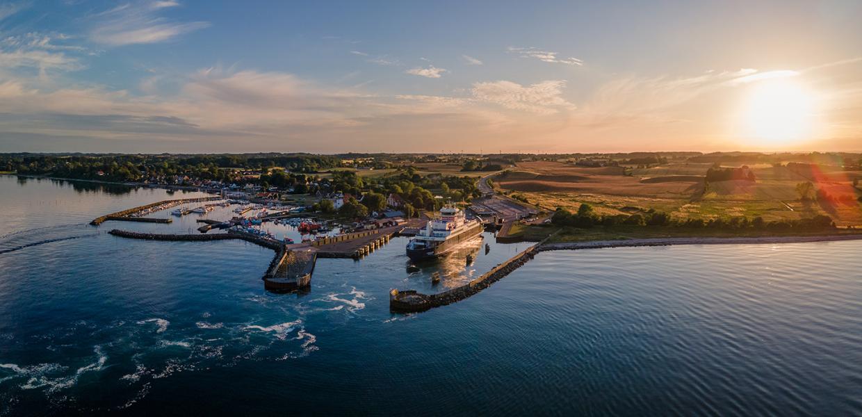 Aerial view of a ferry having just entered Spodsbjerg Harbour, Langeland on a sunny evening.
