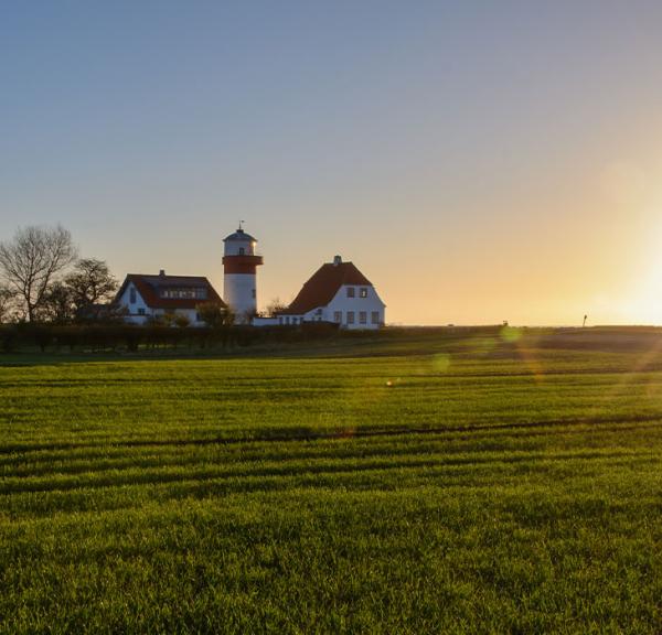Solen står op på en dejlig forårsdag på Langeland og skinner over de grønner marker og fyrtårnet ved Hou,
